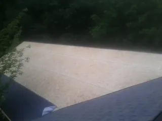 New OSB roof sheathing installed beside an existing shingle roof in Bagdad
