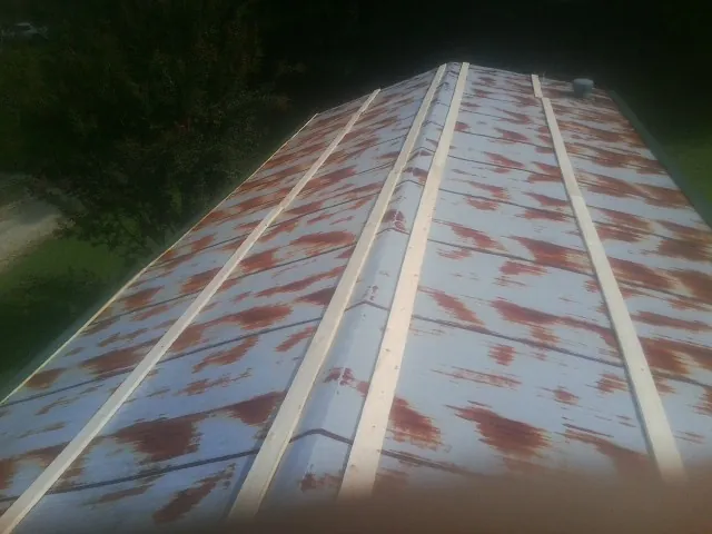 Rusted metal roof panels with new wood purlins before replacement — Storm Damage Roof Repair in Bagdad by Roofing Brothers