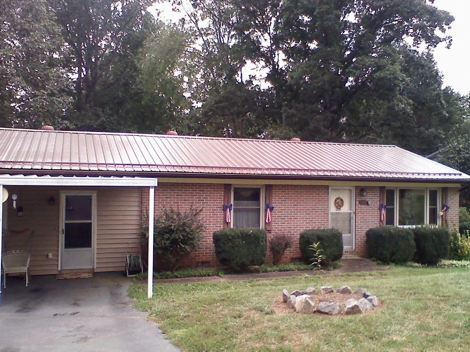 Bronze metal roof and carport on a brick ranch home — Roof Repair work by our crew in Bagdad